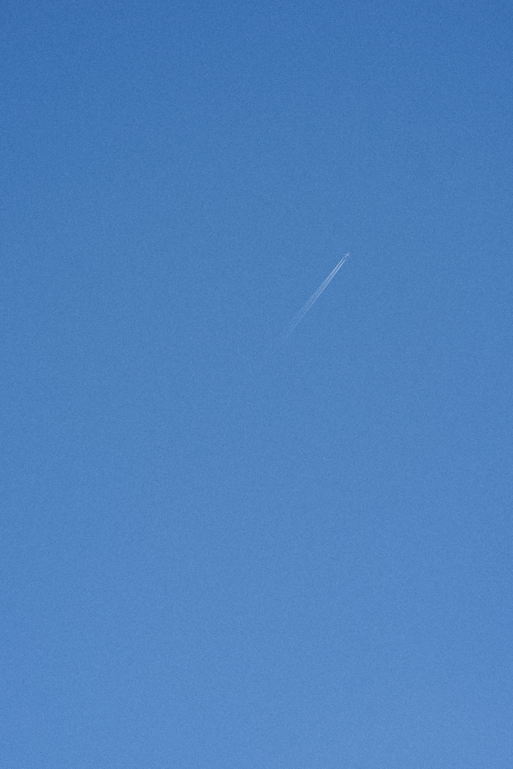 Un avión vuela en el cielo azul