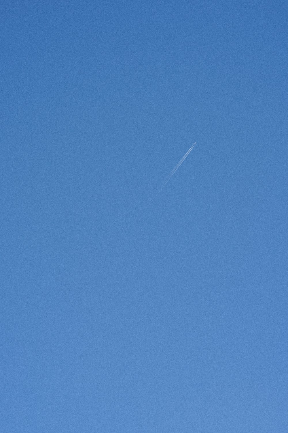an airplane is flying in the blue sky