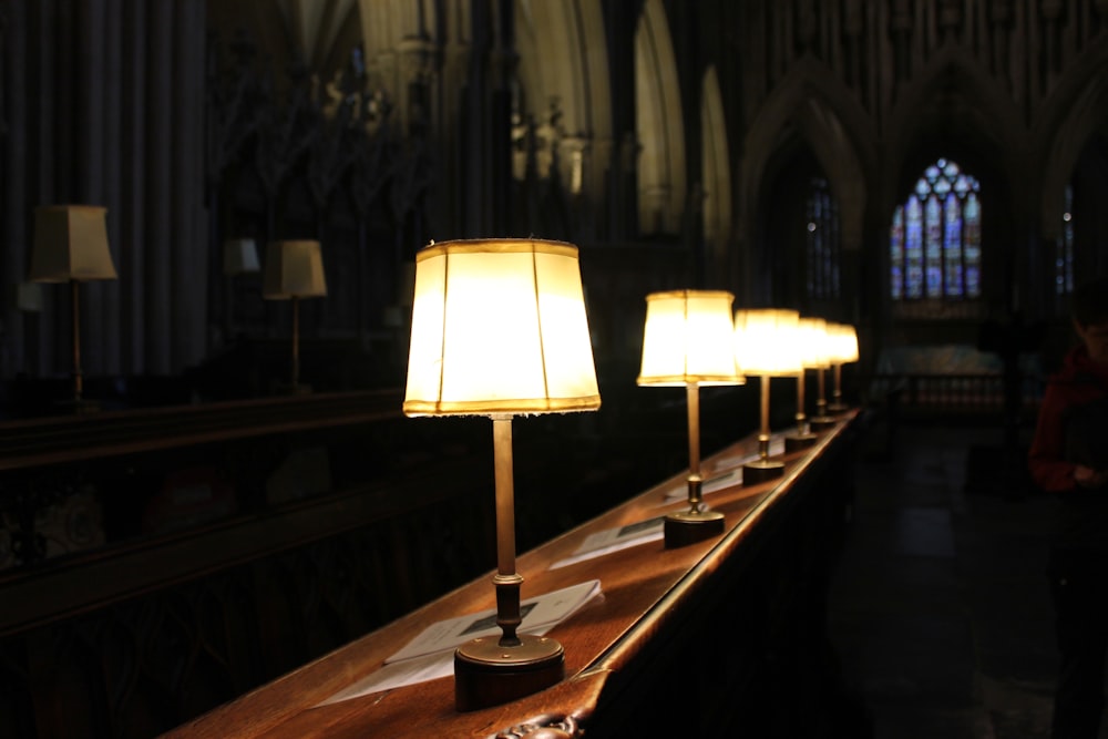 a row of lamps sitting on top of a wooden table