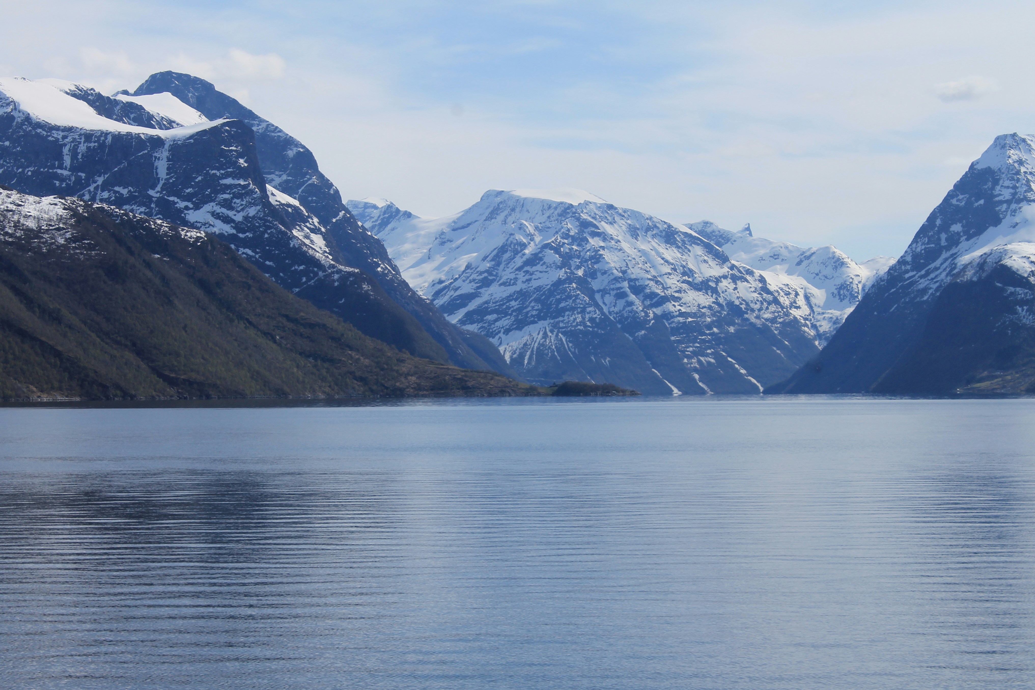 ein großes Gewässer, umgeben von schneebedeckten Bergen