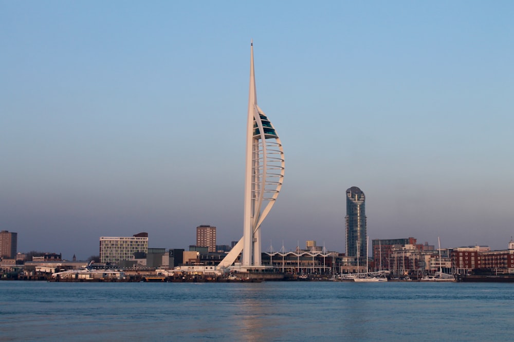 a tall white tower sitting in the middle of a body of water