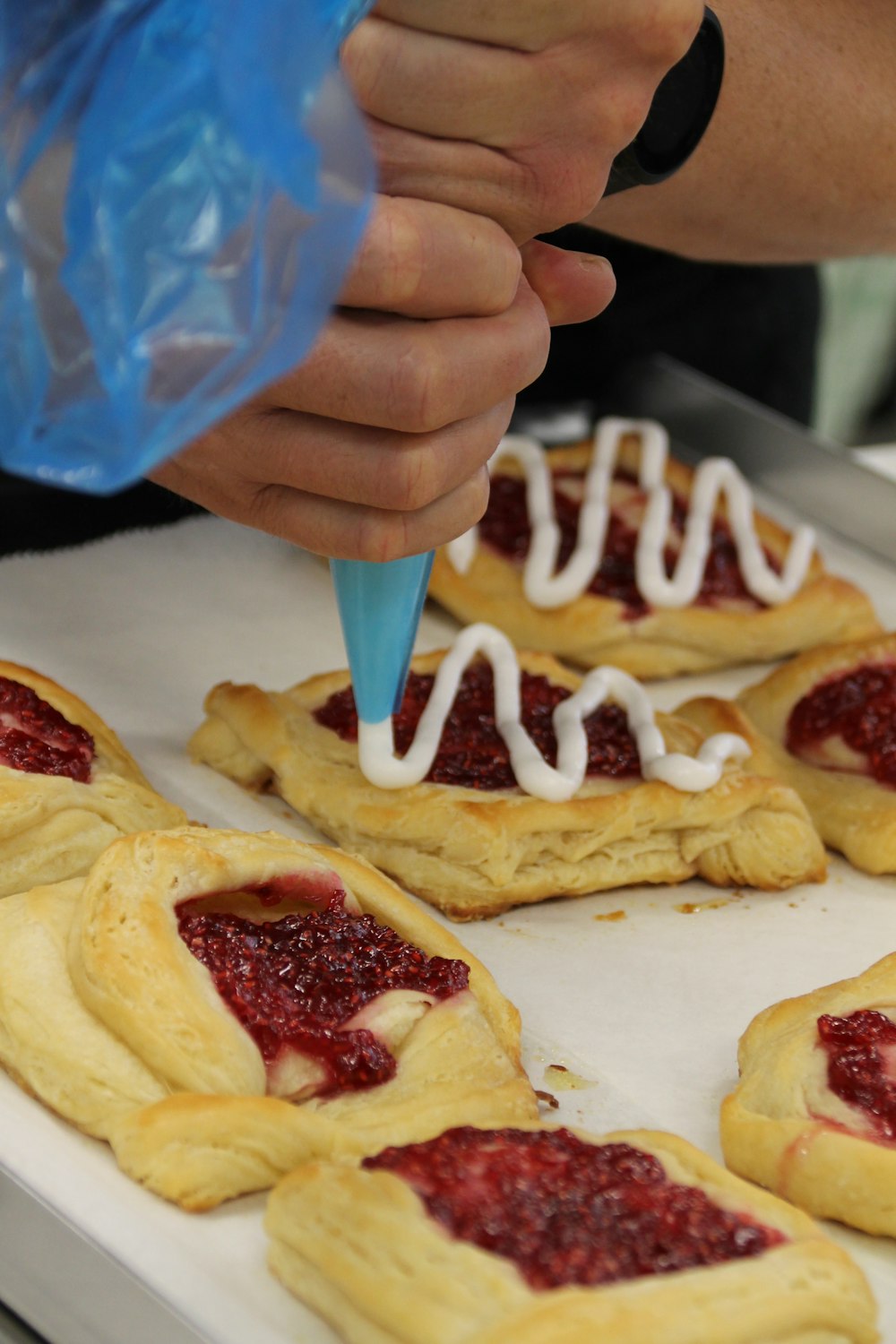 a person is decorating pastries with white icing