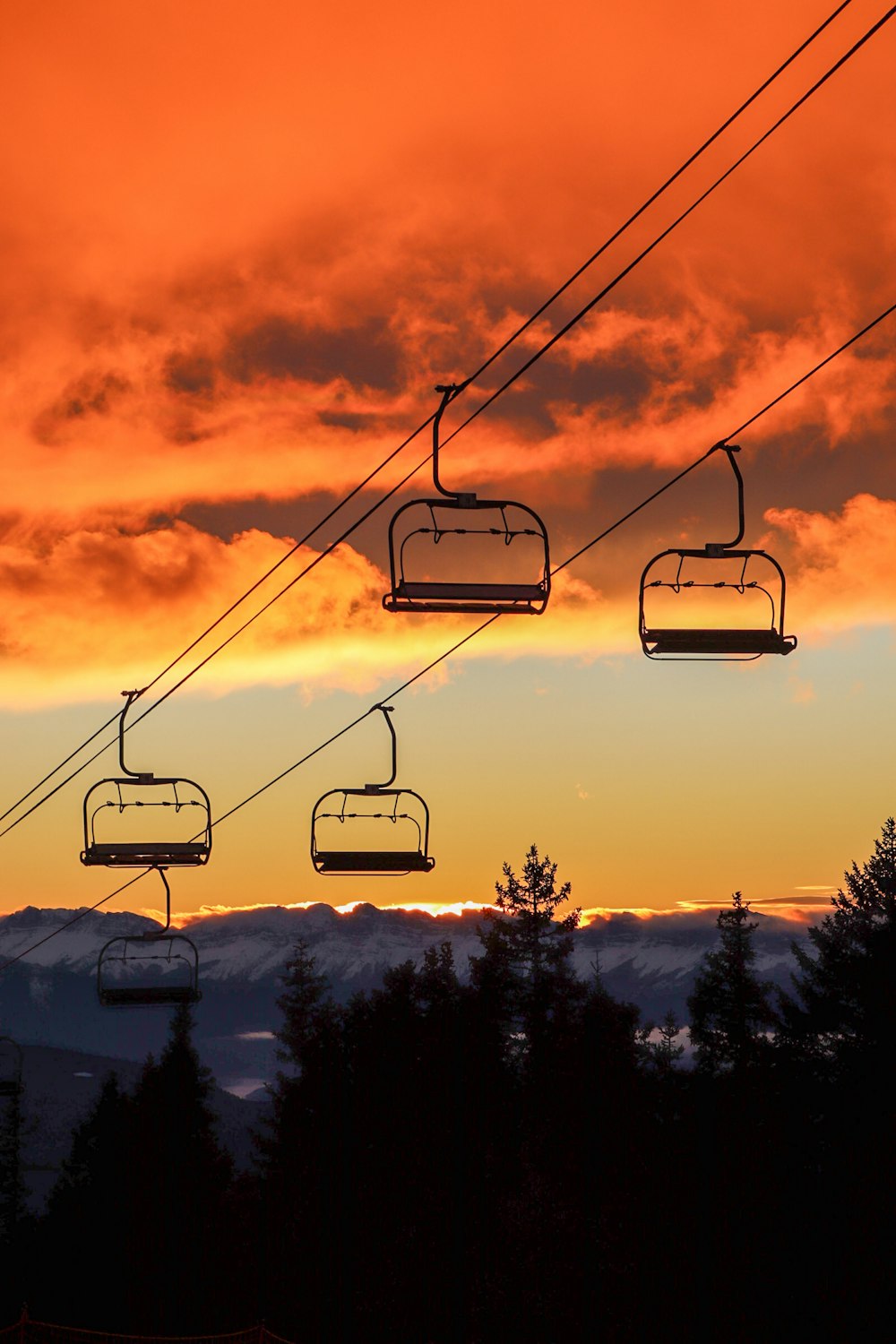 a ski lift going up a mountain at sunset