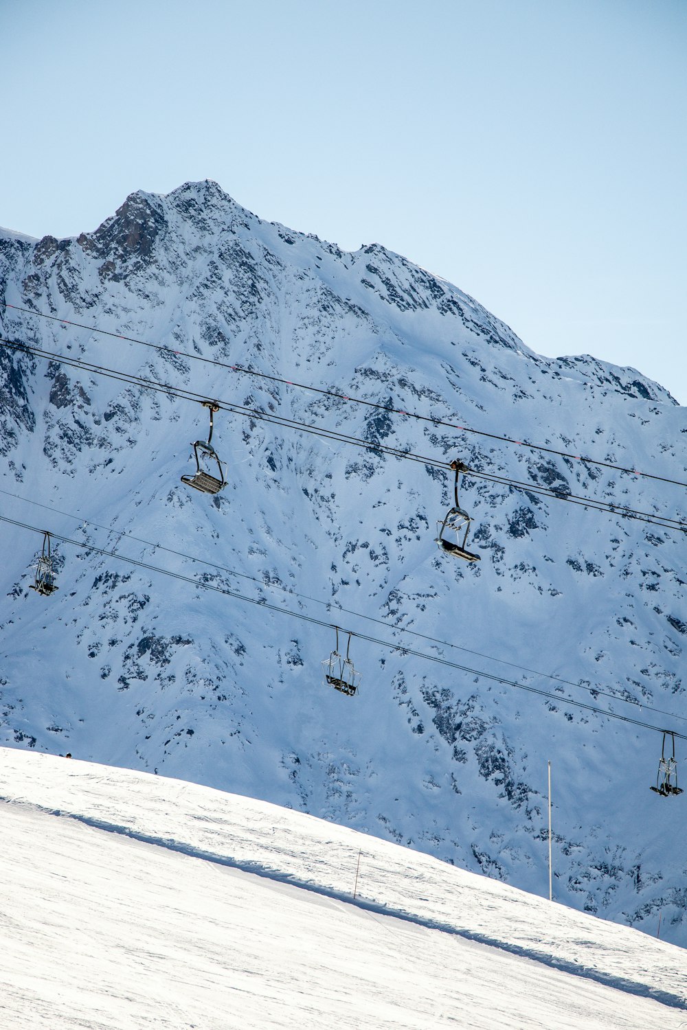 a ski lift going up a snowy mountain