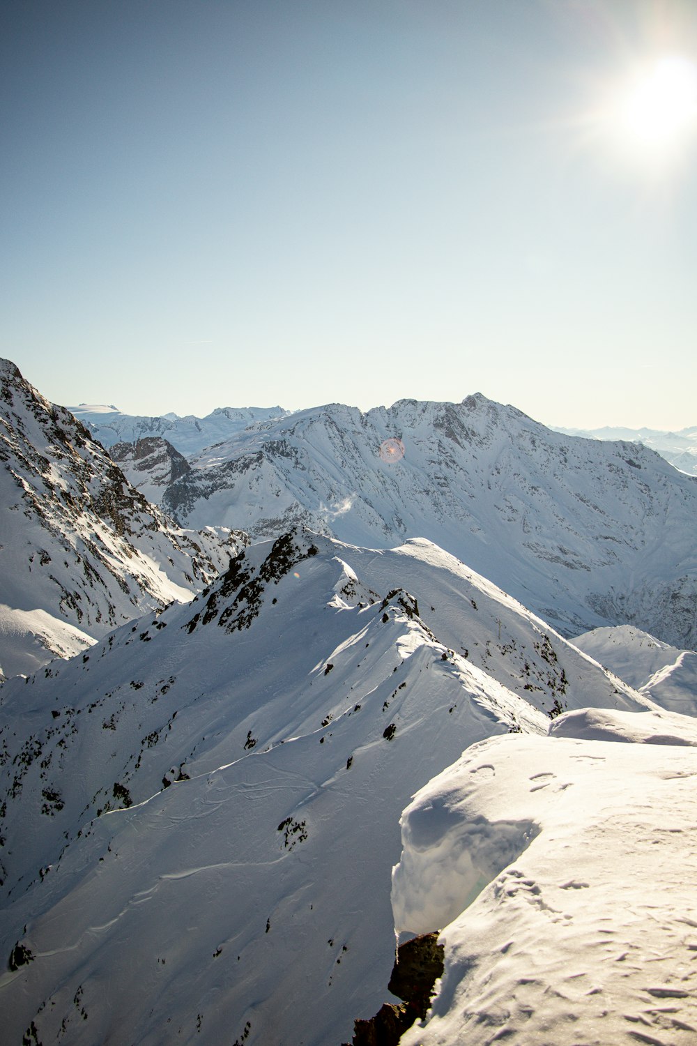 the sun is shining on a snowy mountain