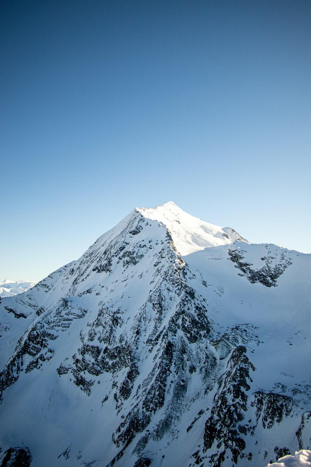 a snow covered mountain under a blue sky