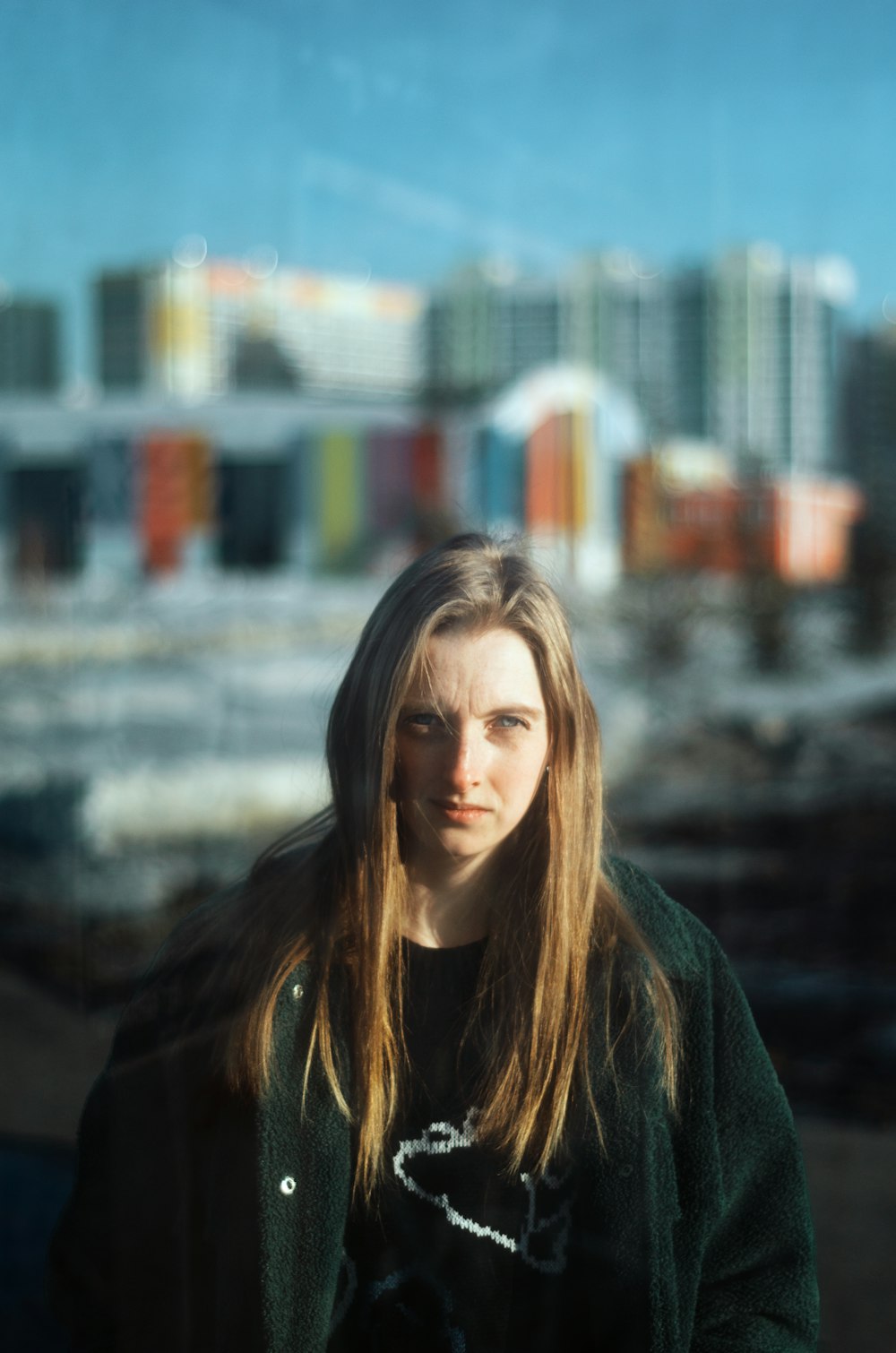 a woman with long hair standing in front of a city