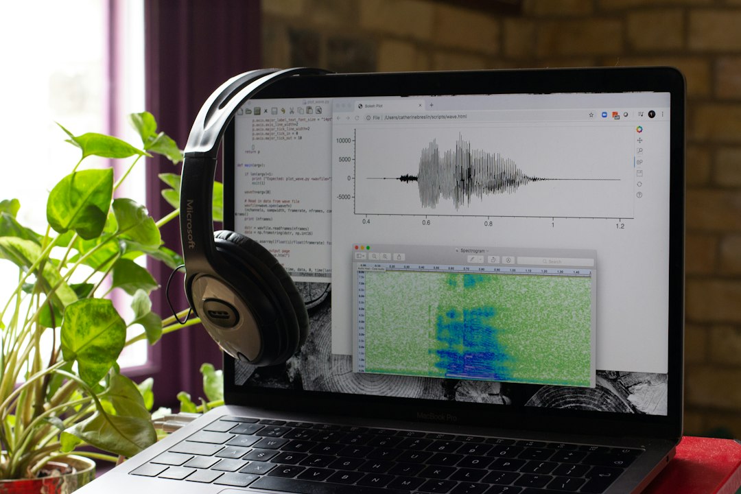 A computer showing sound files open with some computer code and headphones