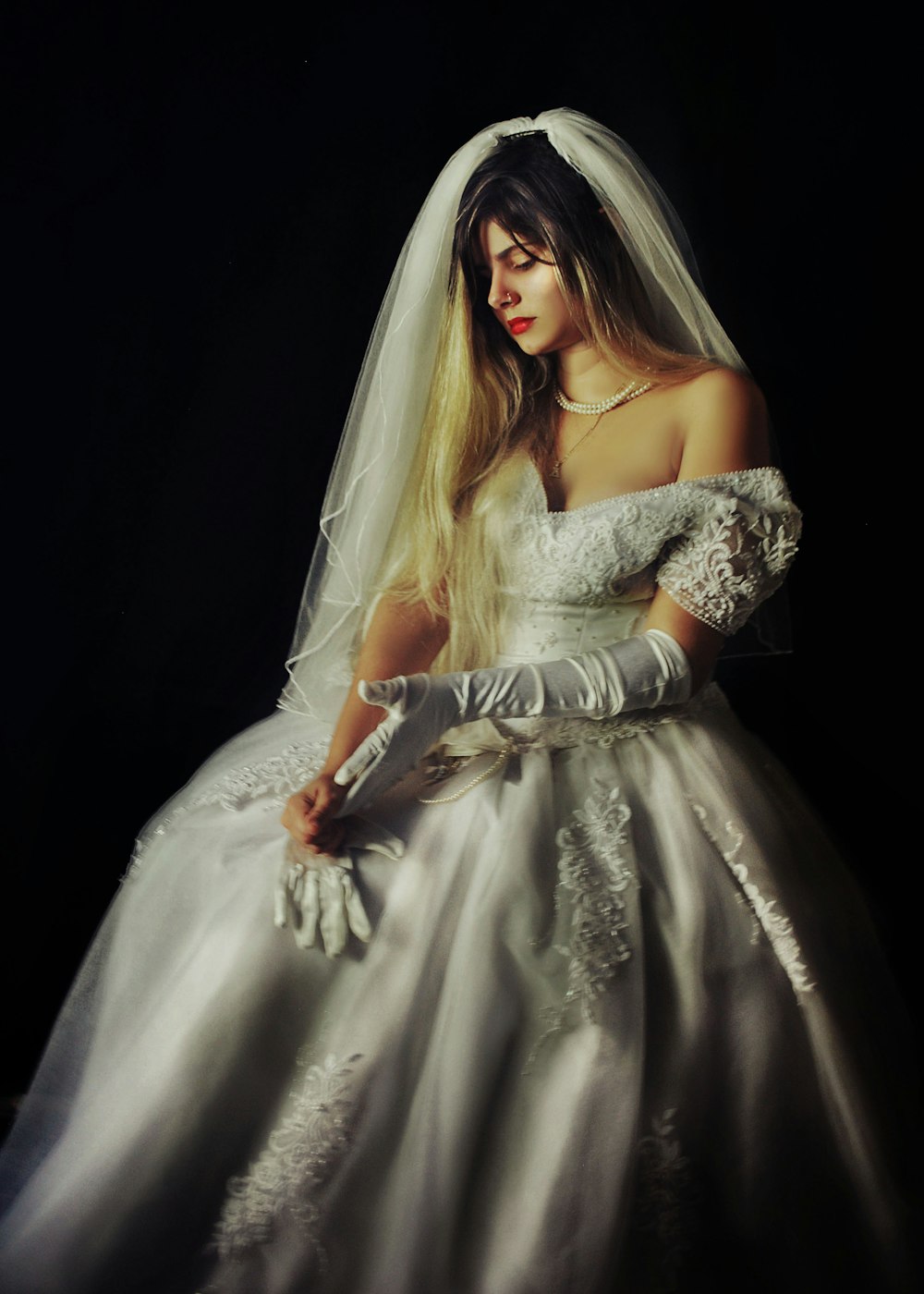 a woman in a white wedding dress and gloves