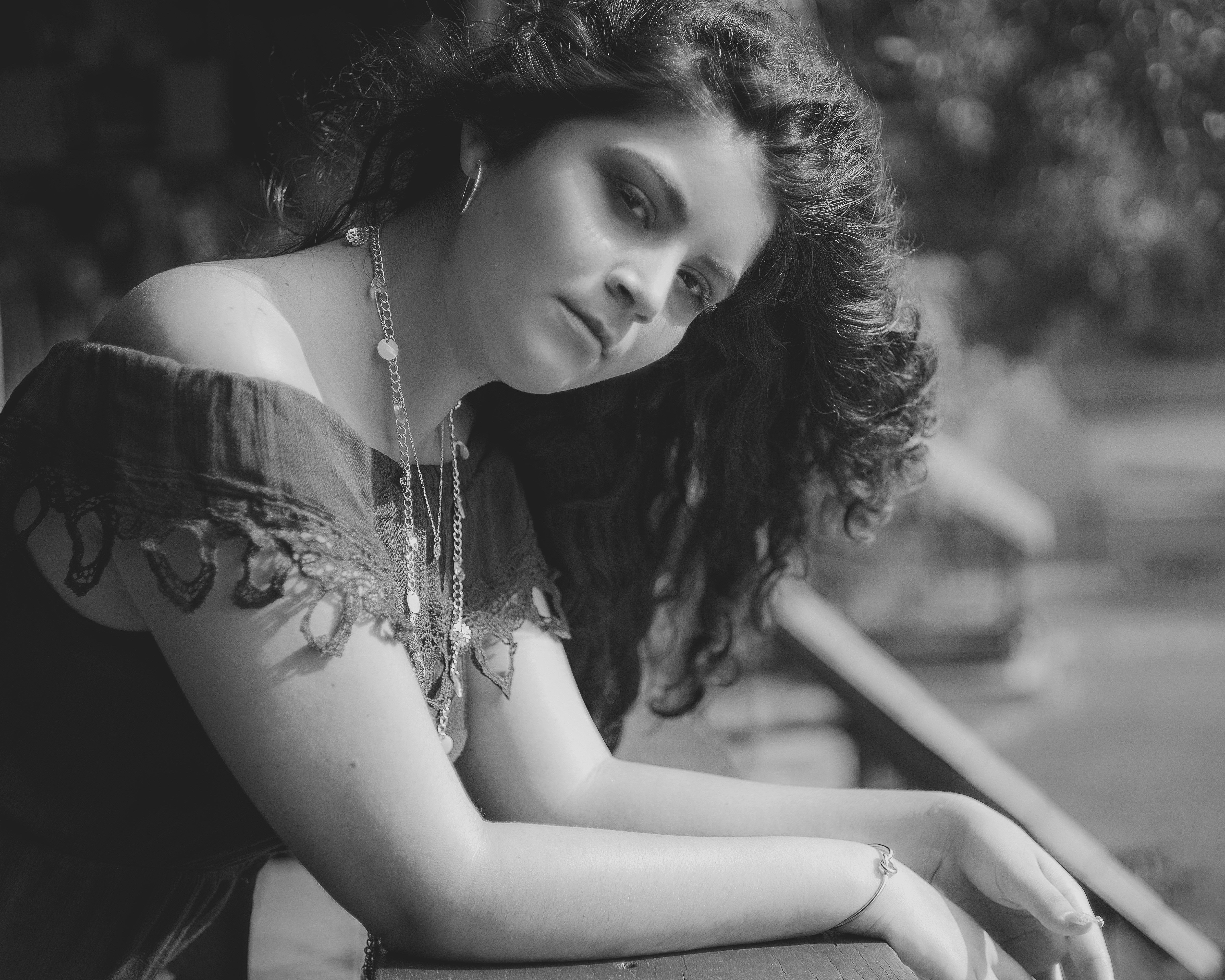 a black and white photo of a woman leaning on a wall