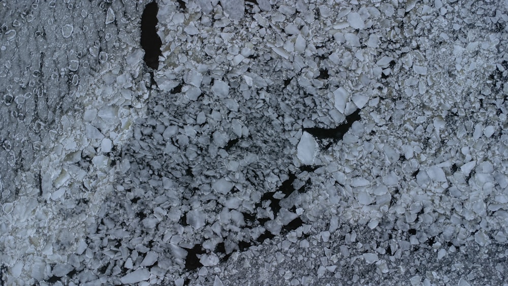 uma foto em preto e branco de neve e rochas