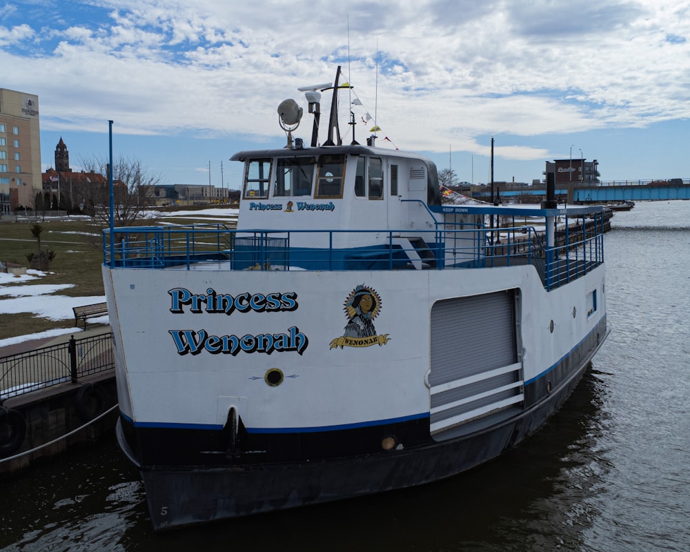 a white and blue boat docked at a pier