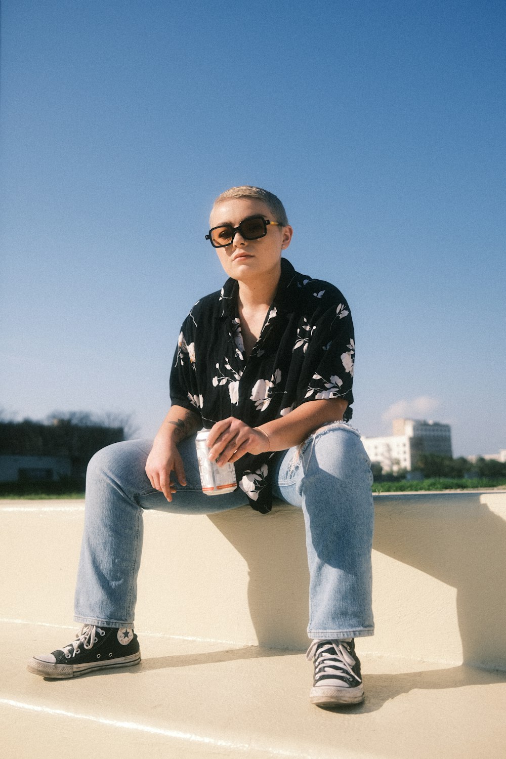 a man sitting on top of a cement wall