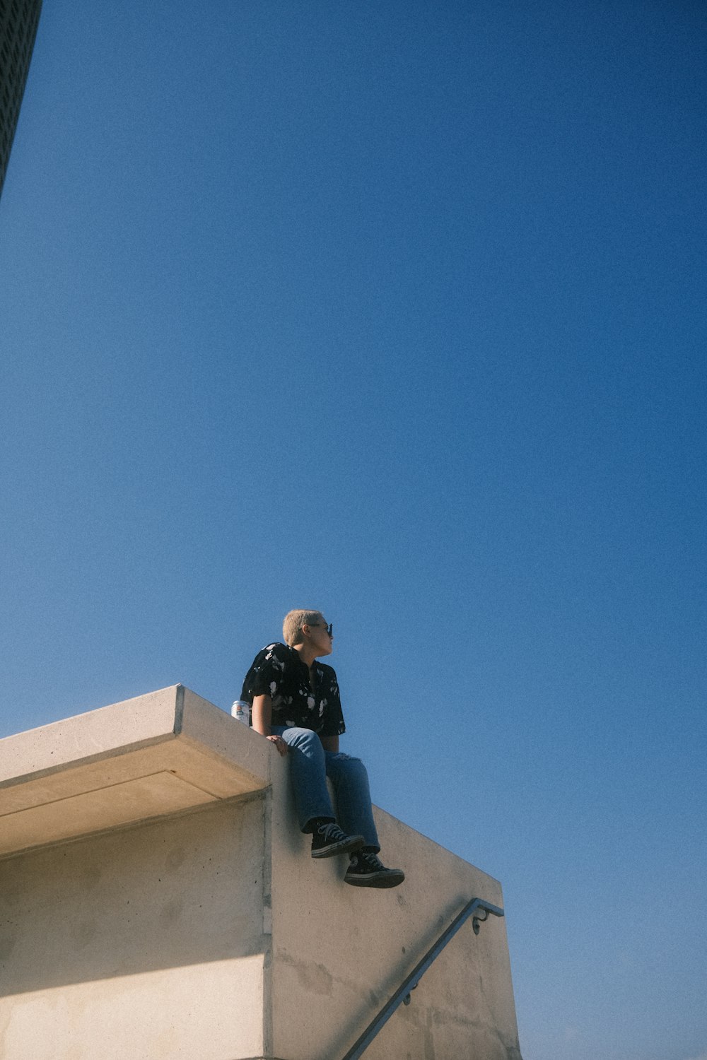 a man sitting on top of a cement structure