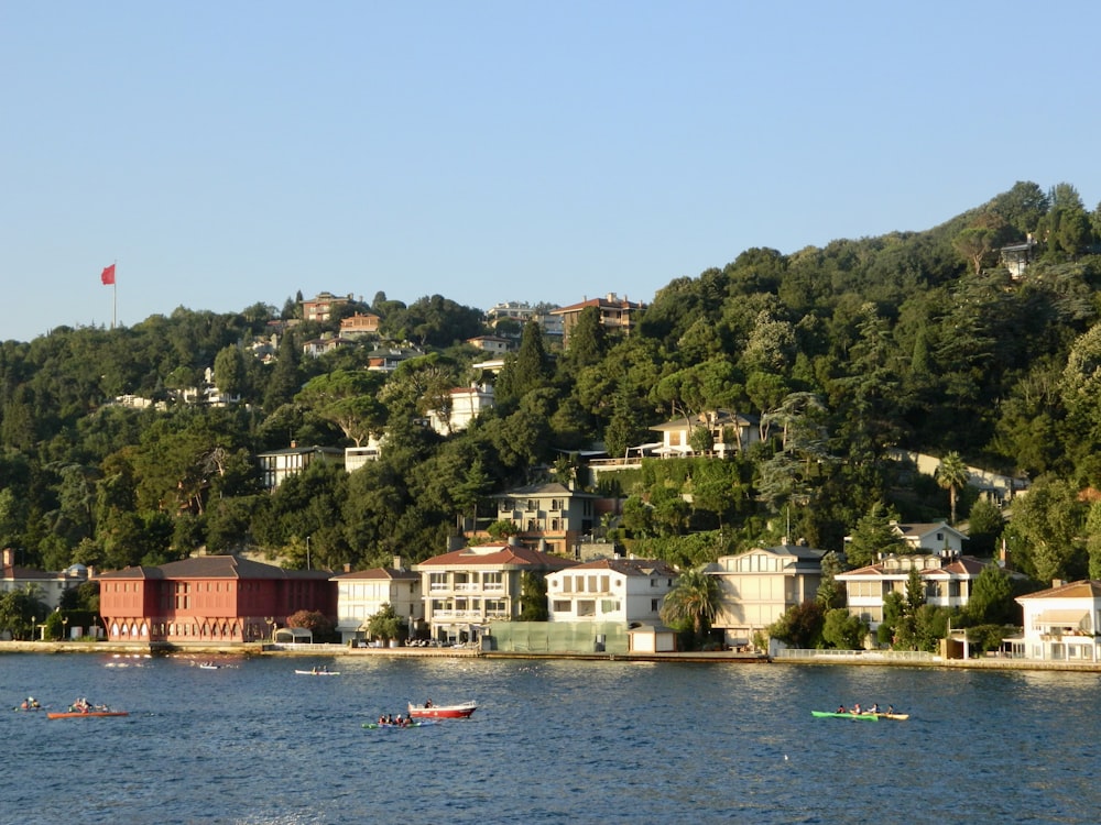 a body of water with houses on a hill in the background