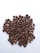 A pile of roasted coffee beans spread out over a white surface, showcasing various shades of brown and some showing visible craters and cracks.