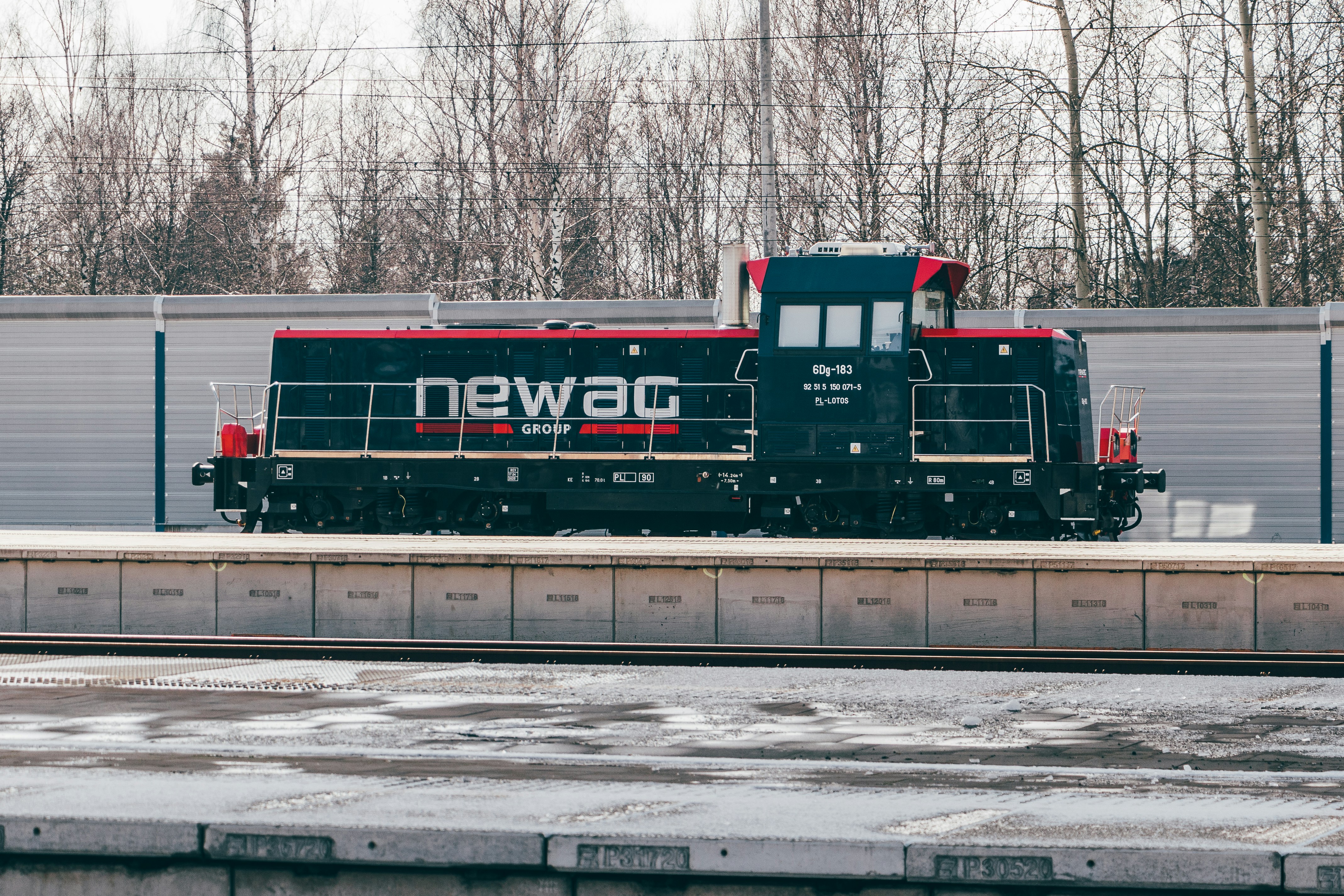 a black and red train traveling down train tracks