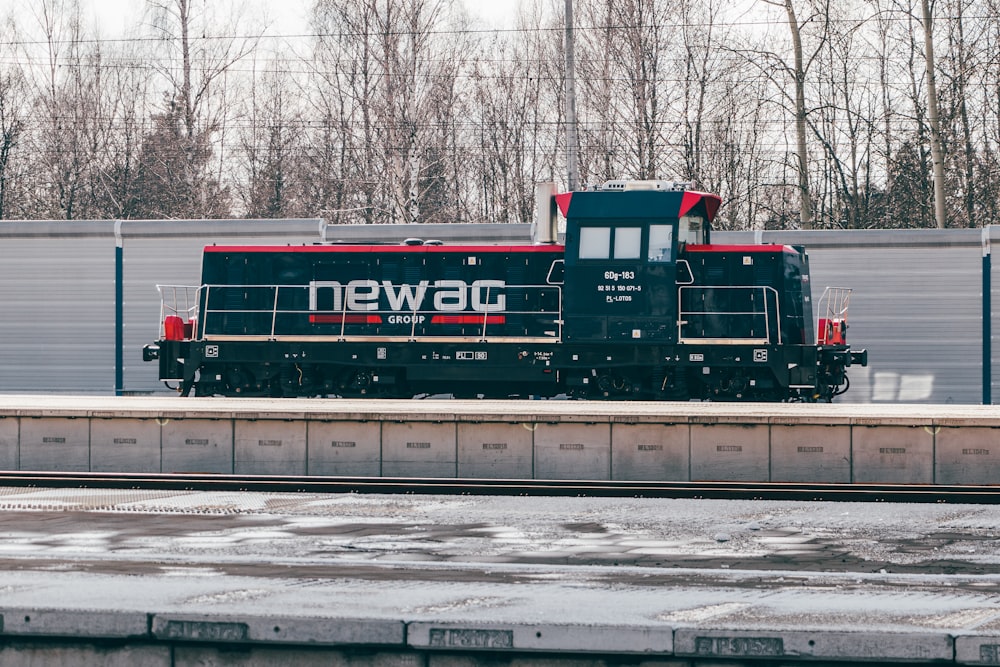 a black and red train traveling down train tracks