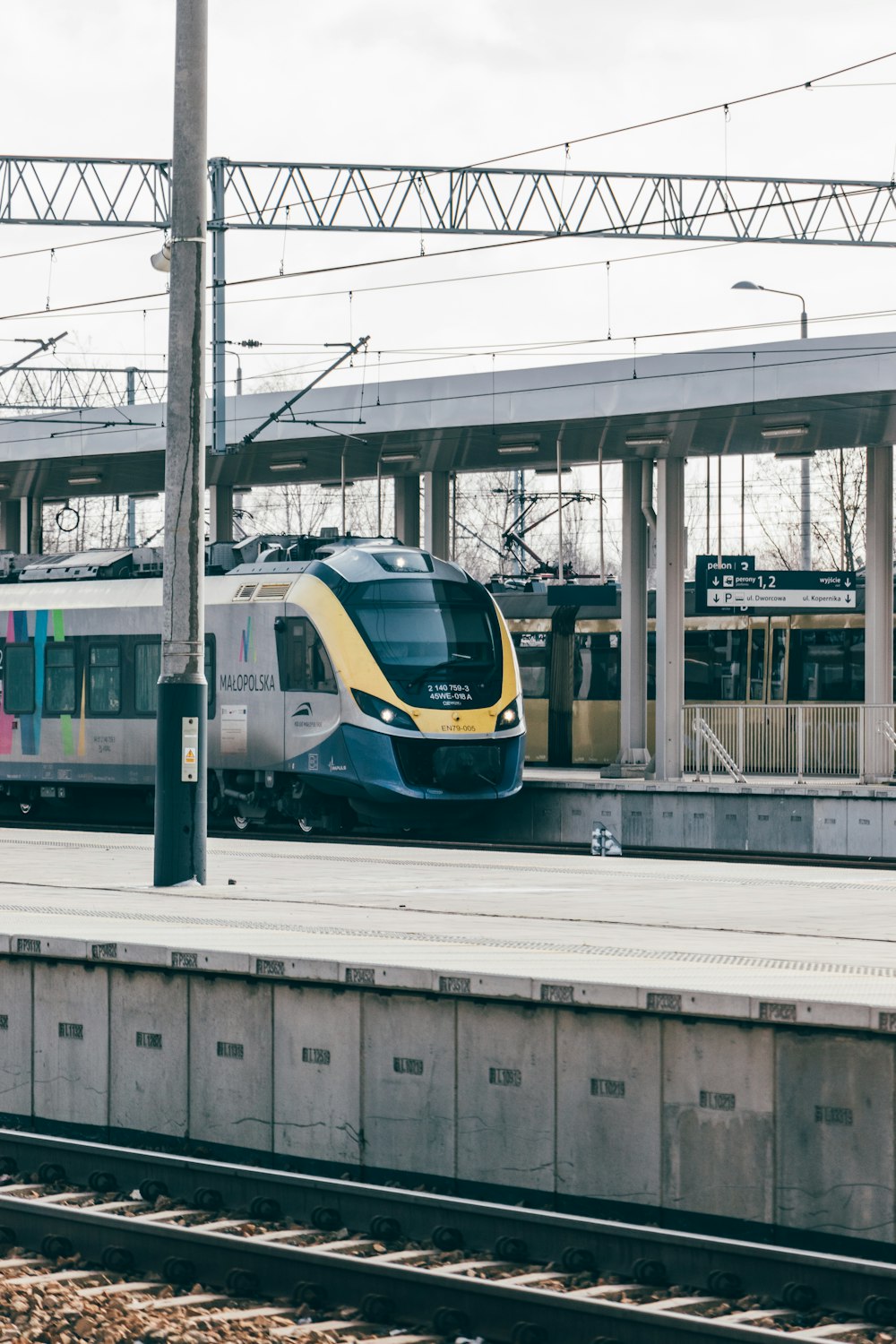 a yellow and blue train pulling into a train station