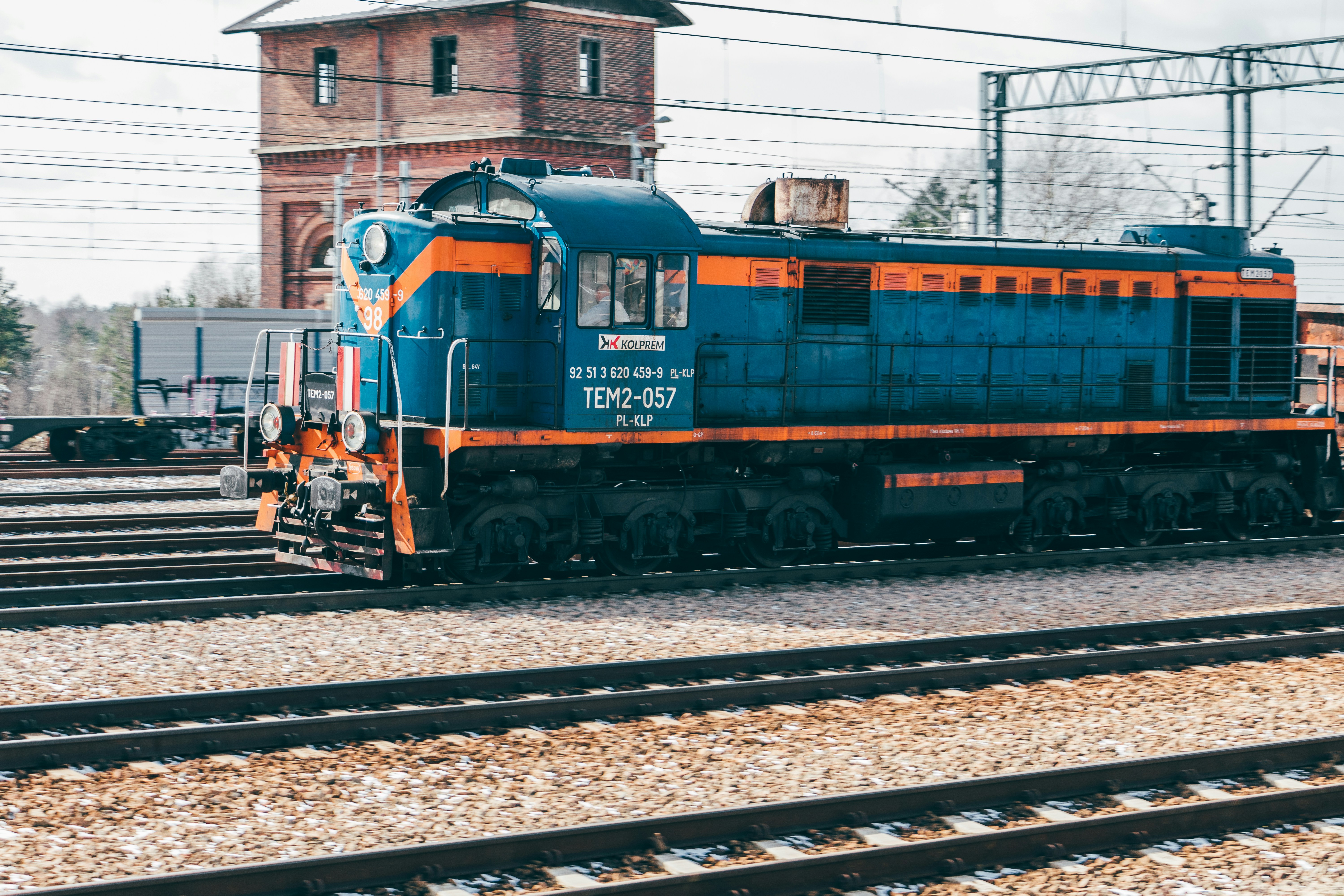 a blue and orange train traveling down train tracks