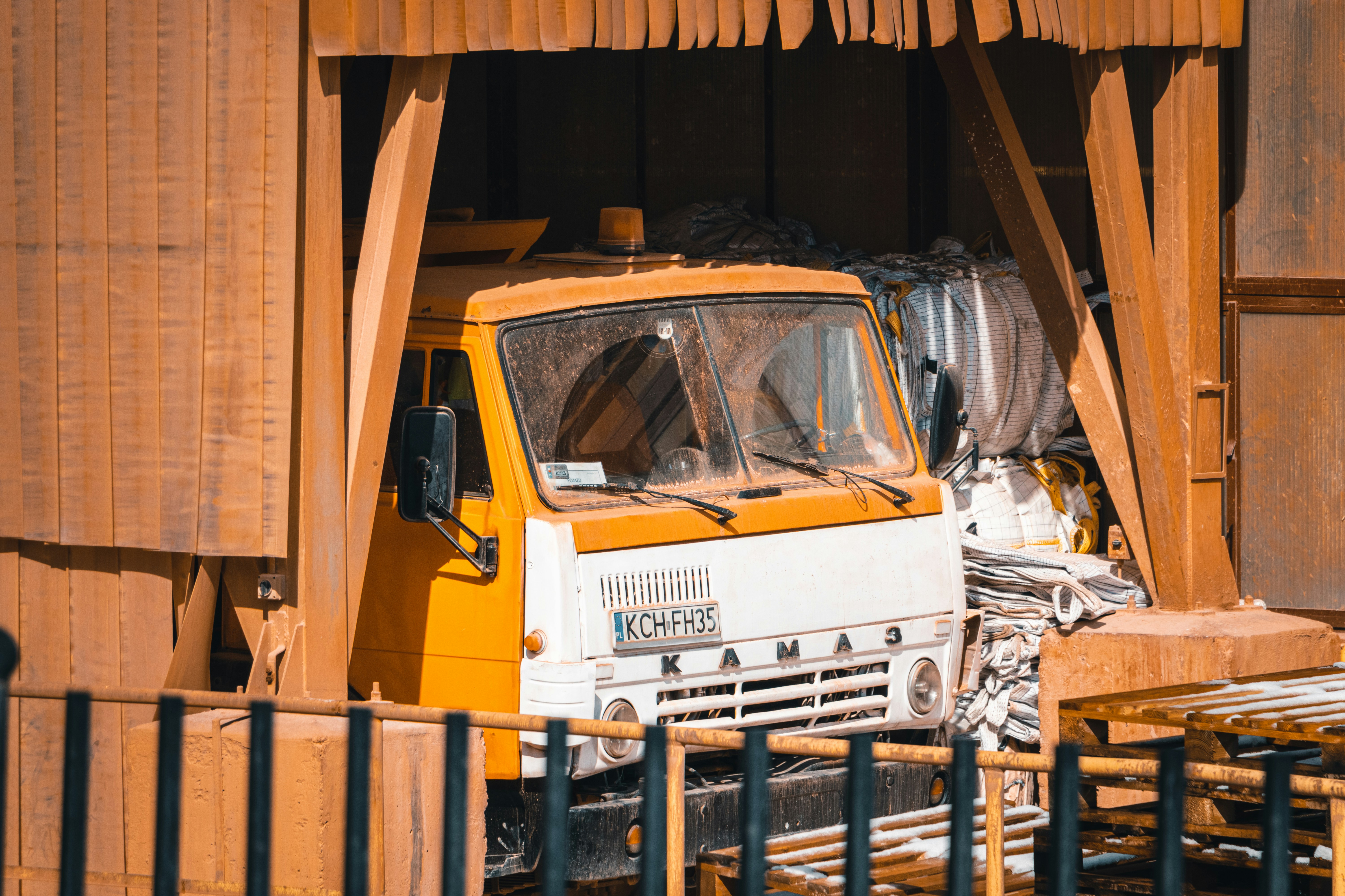 a yellow and white truck parked in front of a building