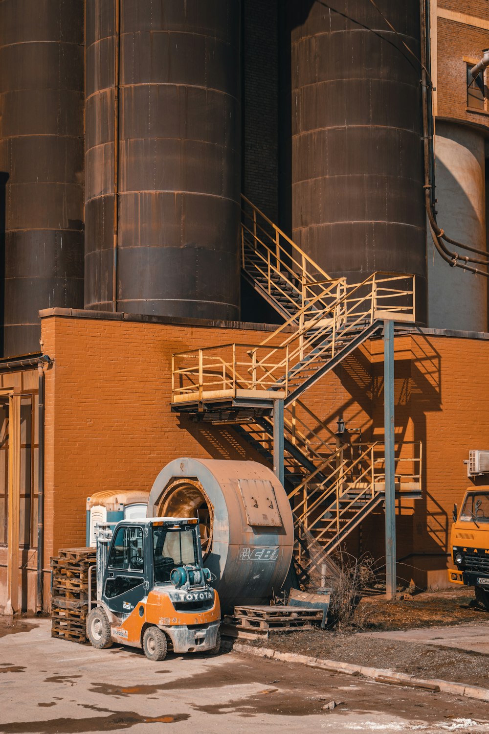 a truck parked in front of a large industrial building