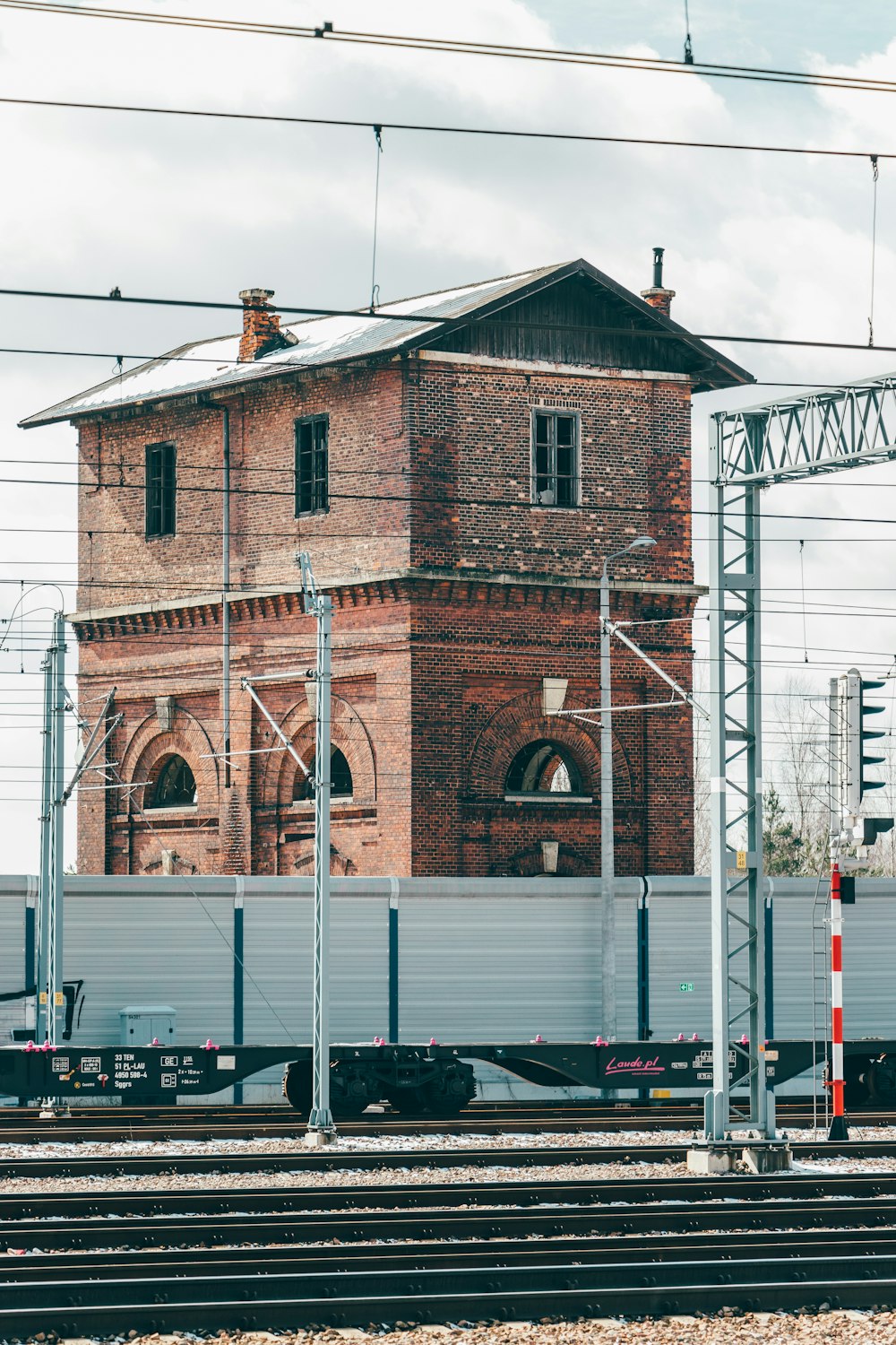 a train traveling past a tall brick building