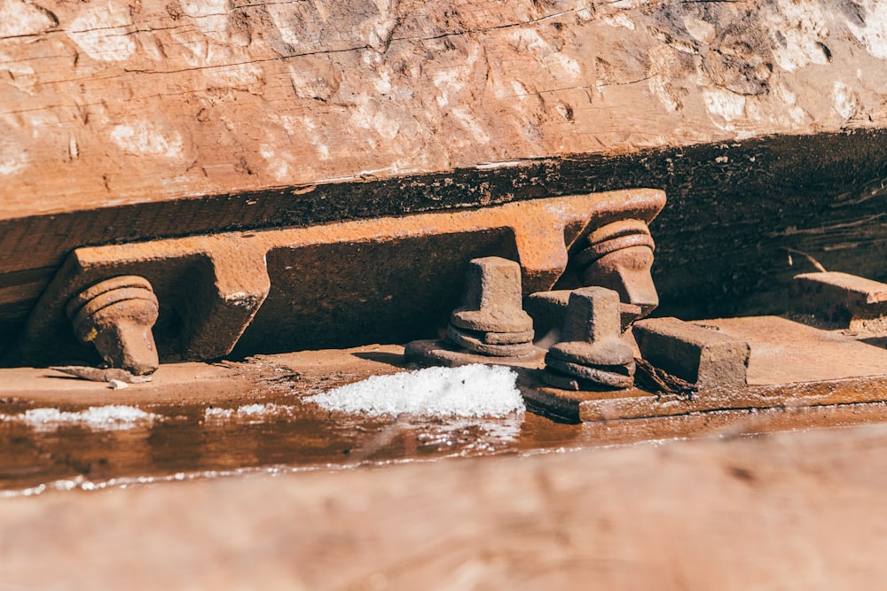 a close up of a water fountain with a rock wall in the background