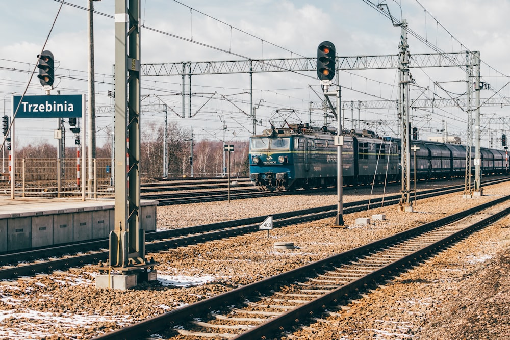 a train traveling down train tracks next to a traffic light