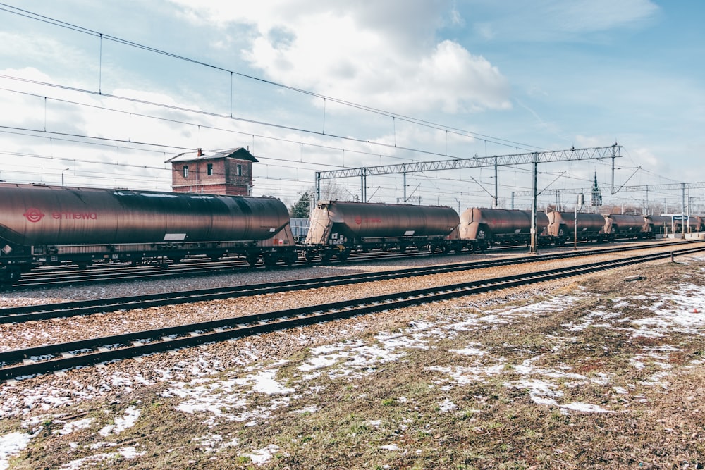 a train traveling down train tracks next to a field