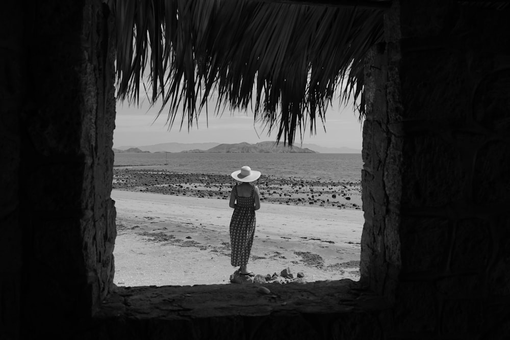 a person wearing a hat standing in front of a hut