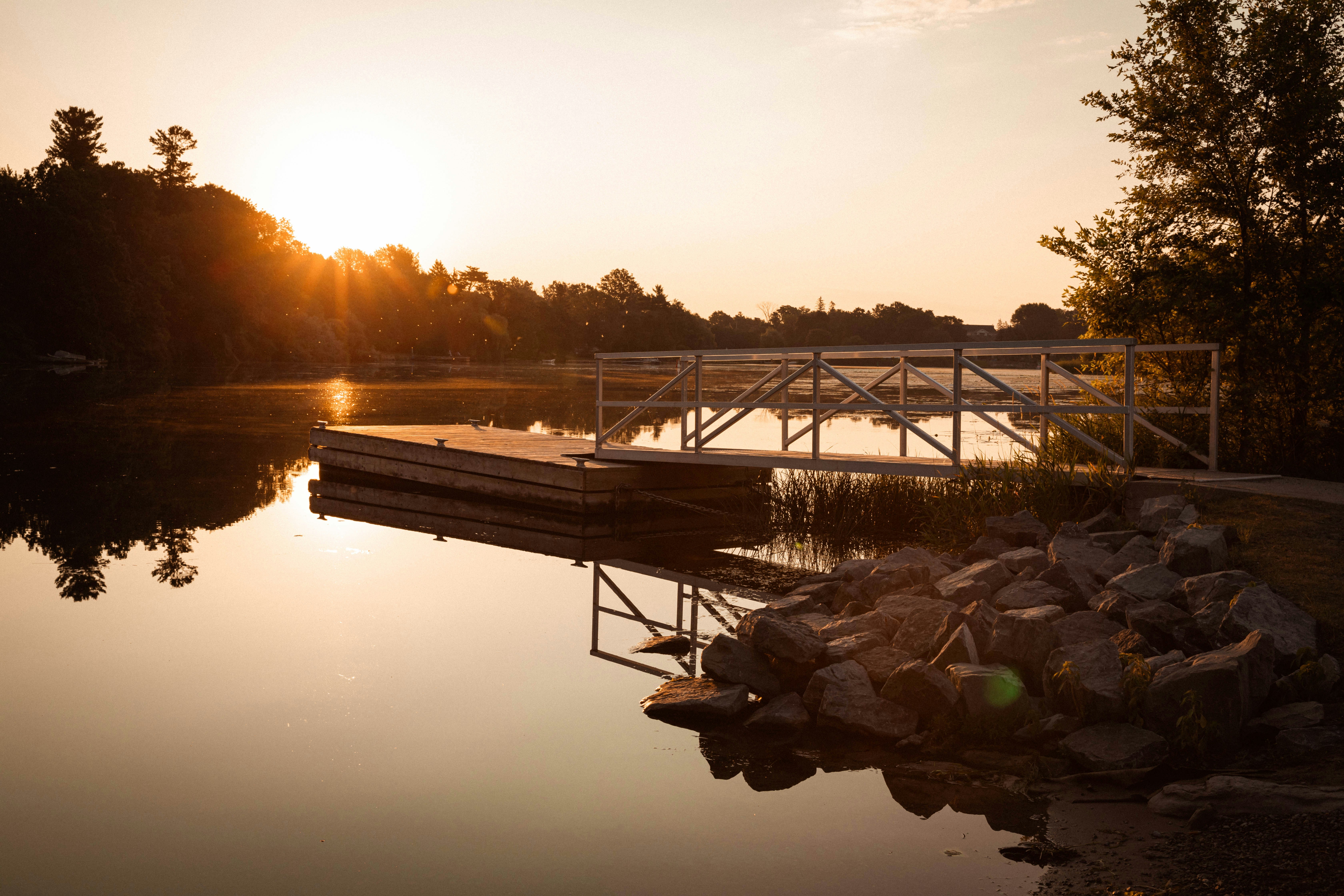 Un molo seduto accanto a un lago al tramonto