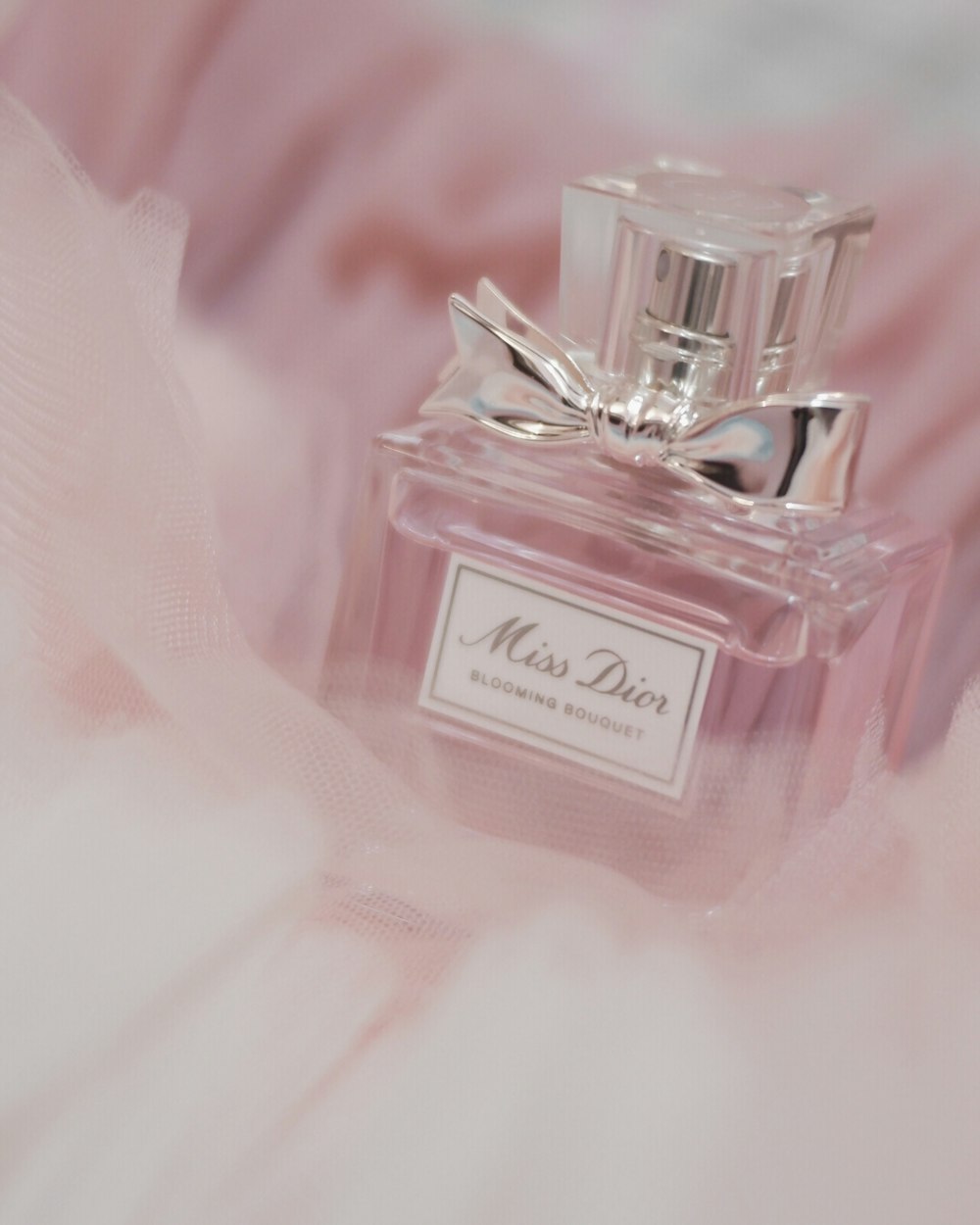 a bottle of perfume sitting on top of a bed