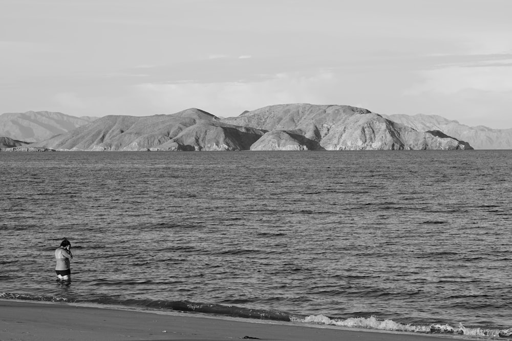 a person standing on a beach next to the ocean