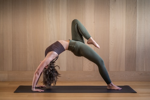 a woman is doing a yoga pose on a mat