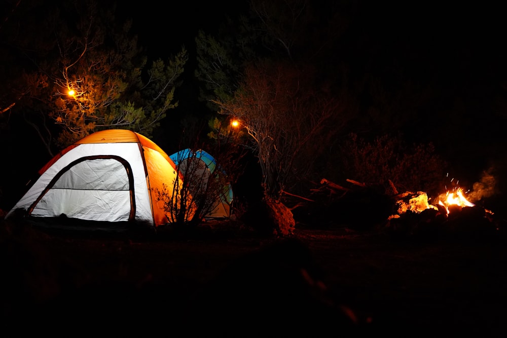 a tent is lit up in the dark