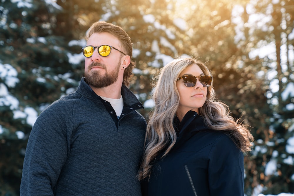 a man and a woman are standing in the snow