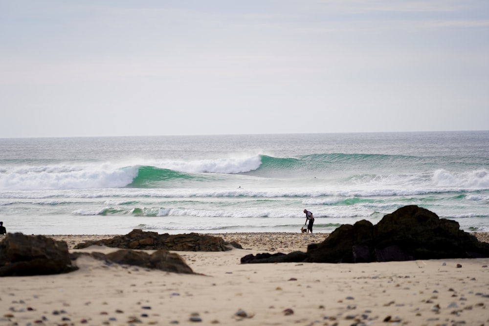 a person standing on a beach with a surfboard