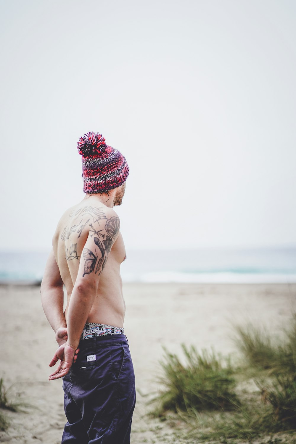 Un hombre con un sombrero parado en una playa