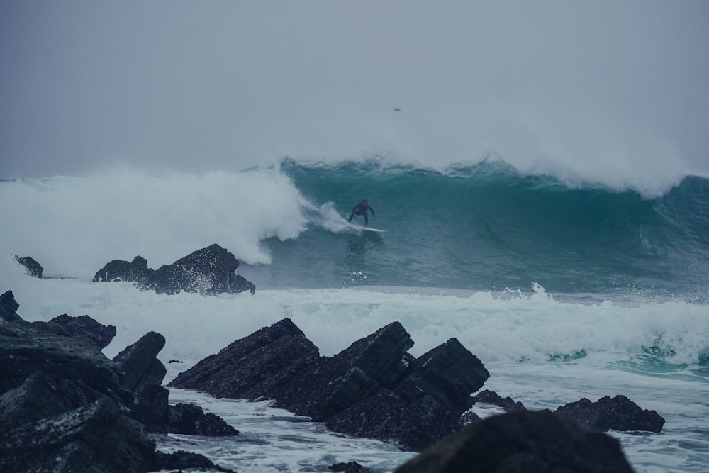 a man riding a wave on top of a surfboard