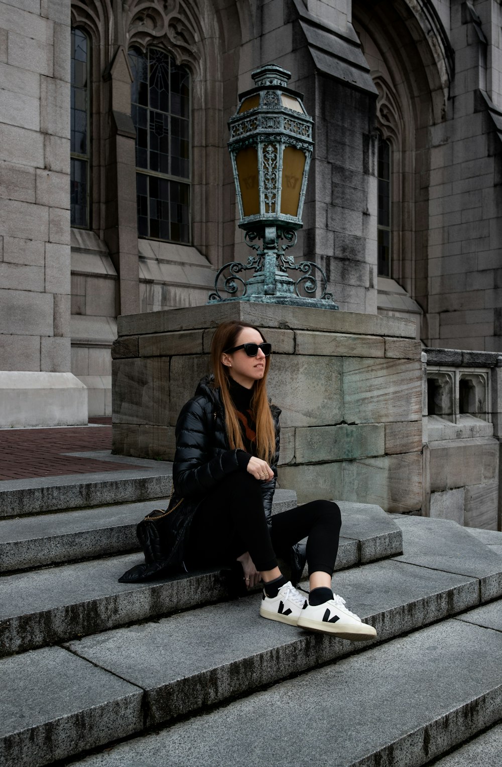 a woman sitting on the steps of a building