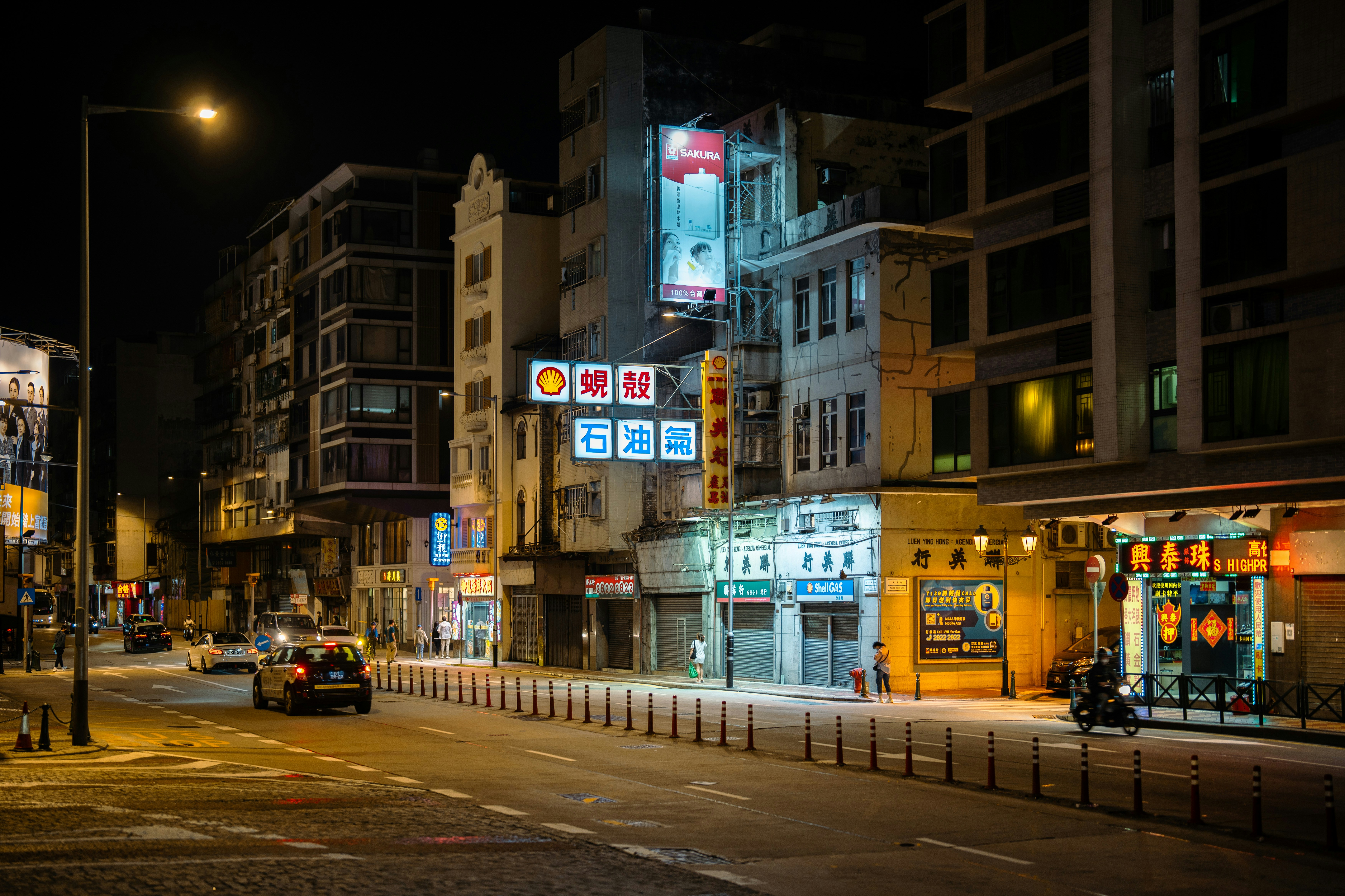 Eine Stadtstraße bei Nacht mit Autos und Gebäuden