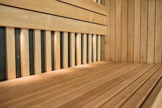 Cozy sauna room with wooden benches glowing in warm light.
