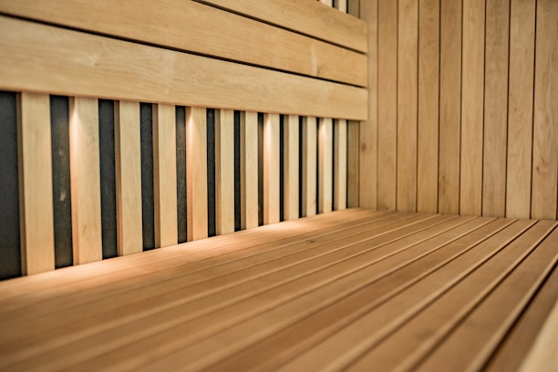 A serene sauna interior with wooden benches and soft lighting, inviting relaxation and warmth.