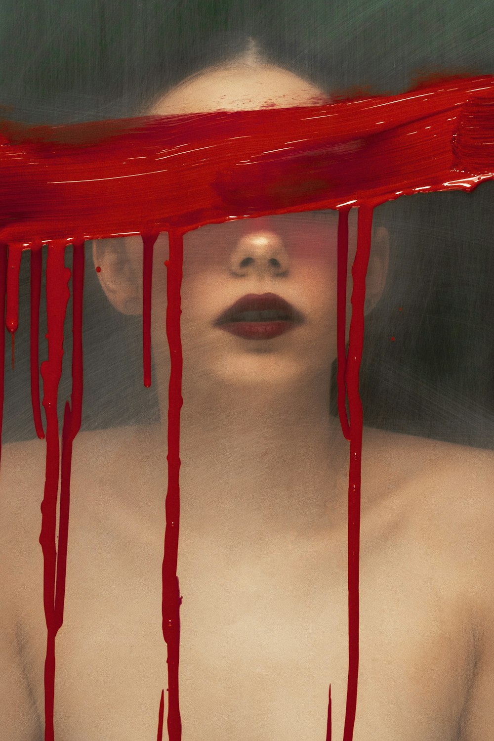 une femme avec de la peinture rouge dégoulinant sur son visage