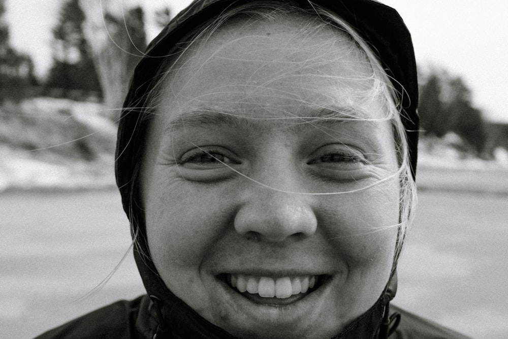 a black and white photo of a woman smiling