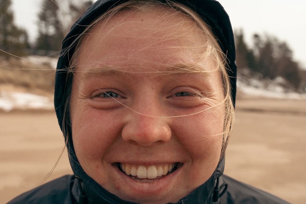 a close up of a person wearing a jacket and smiling