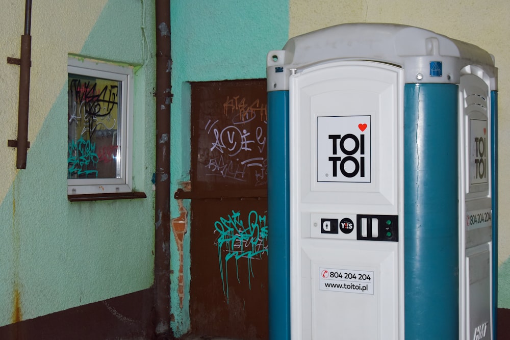 a blue and white toilet sitting next to a building