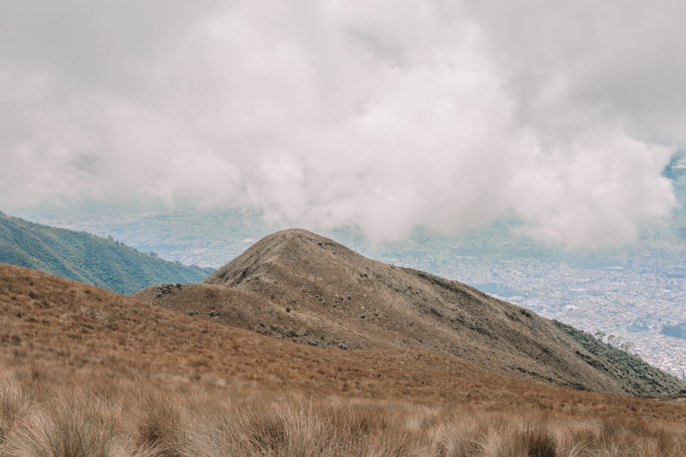 a grassy hill with a mountain in the background