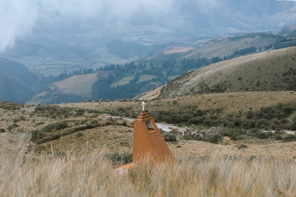 uma estrada no meio de um campo com montanhas ao fundo